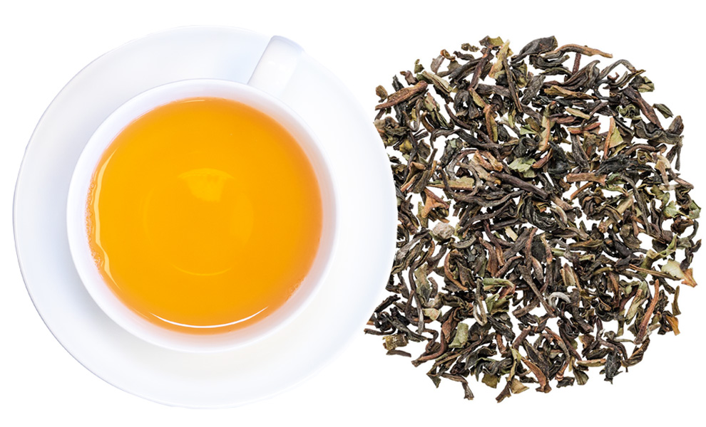 Weiße Tasse mit aufgebrühtem losem Schwarztee