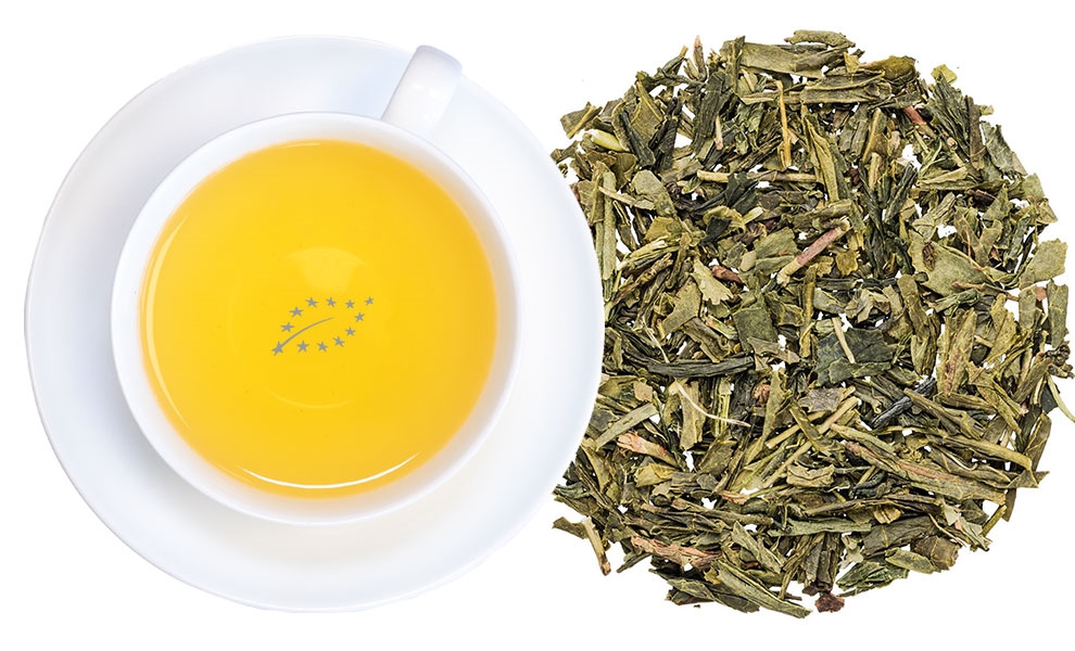 Weiße Tasse mit aufgebrühtem grünem Tee und Blatttee, tee, grüner tee, tee blätter, lose blatttee, infusion