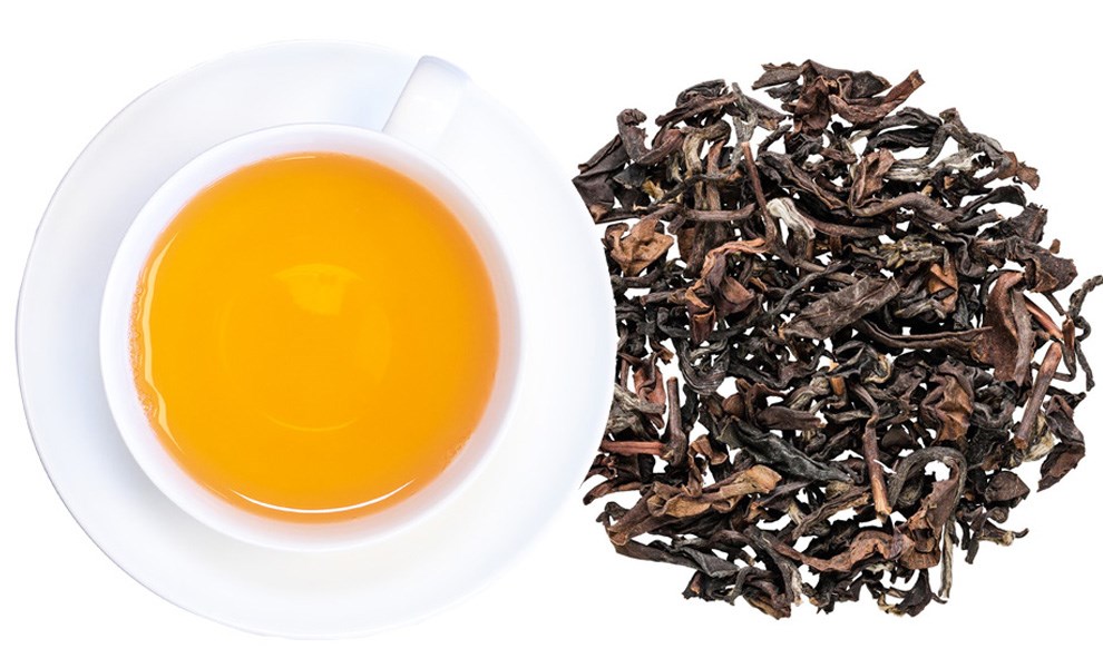 Weiße Tasse Schwarztee neben losen Teeblättern, Tees, Schwarzer Tee, Tee, Blättertee, Kraut?