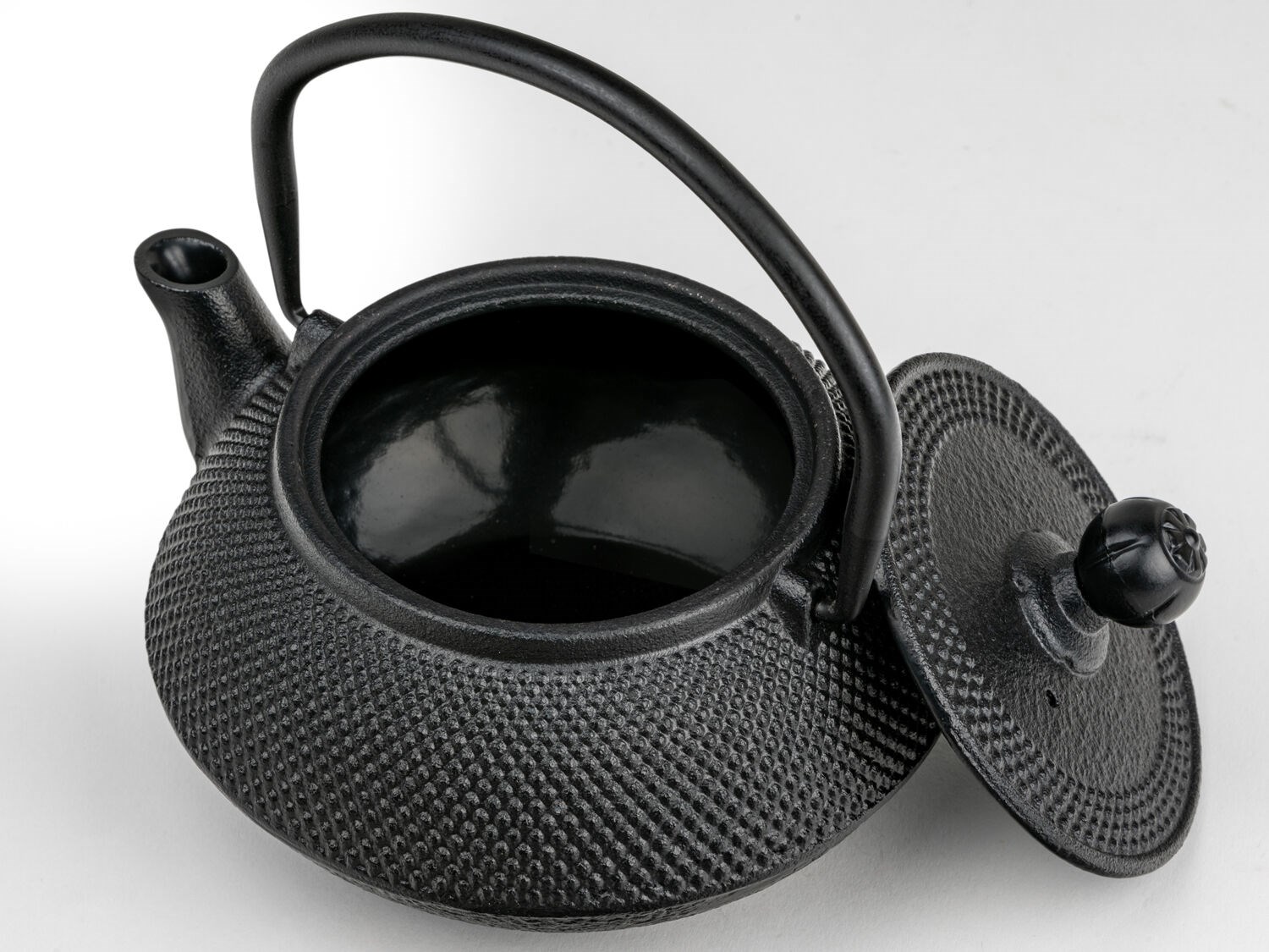 Black cast iron teapot with open lid