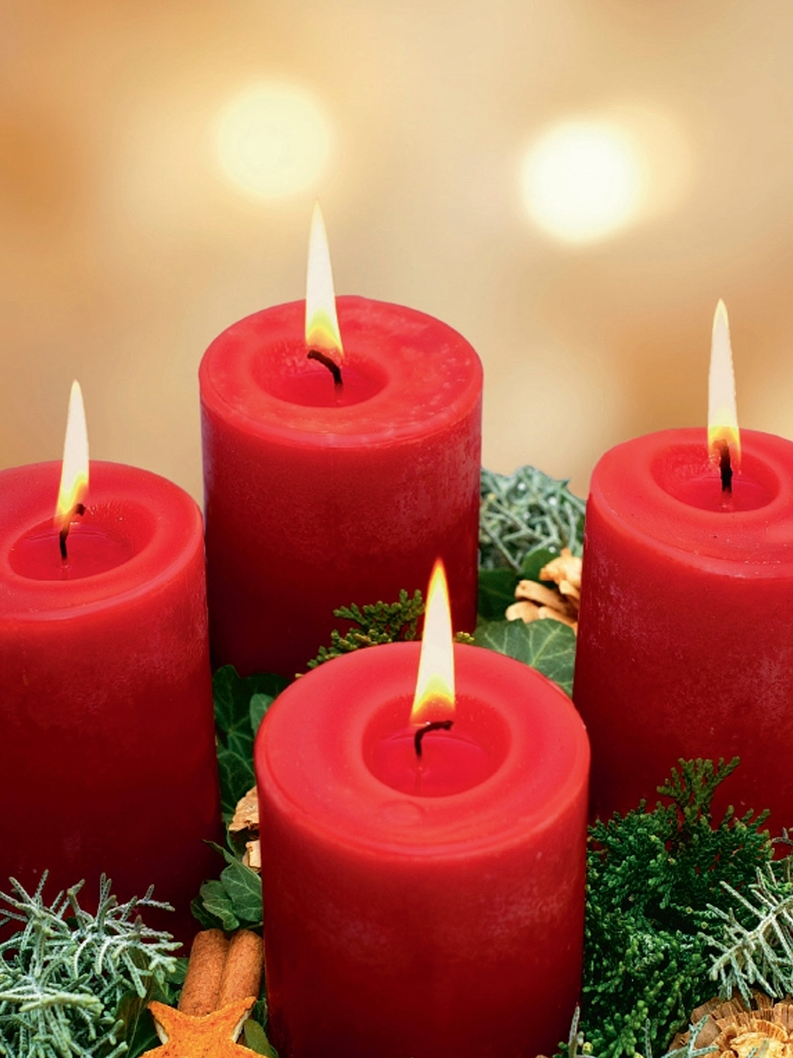 Vier rote Adventskerzen mit grüner Dekoration Vier rote Adventskerzen mit grünem Schmuck