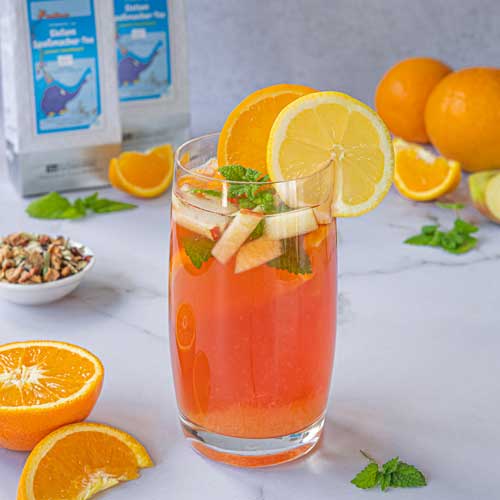 Glas mit Orangen-Apfel Getränk dekoriert mit Zitronenscheibe