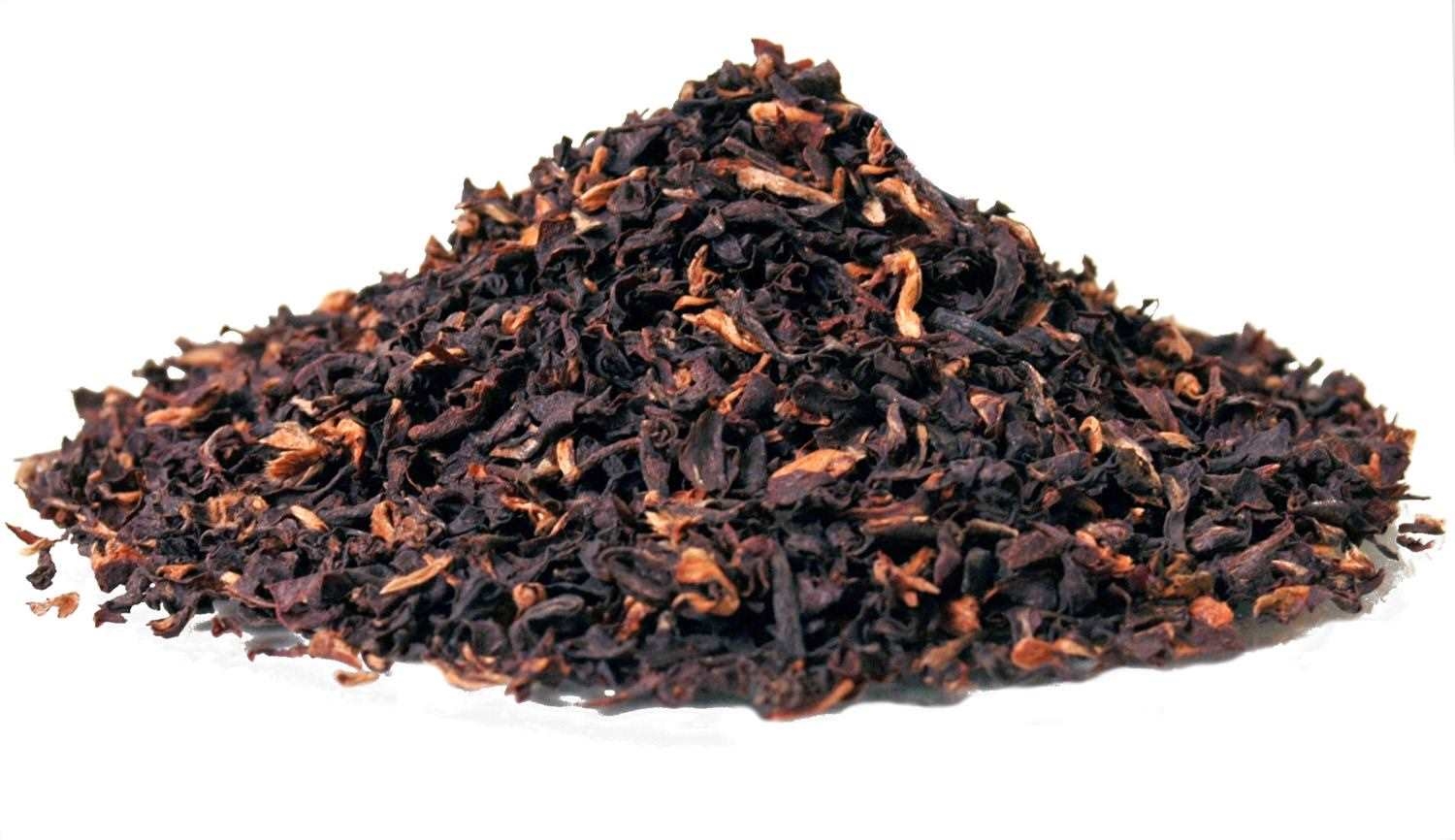 Haufen loser schwarzer Teeblätter auf Weiß, Hagebutter, Hibiskus-Tee, Schwarztee, TEE-Blätter, Kraeuter-Teemischung