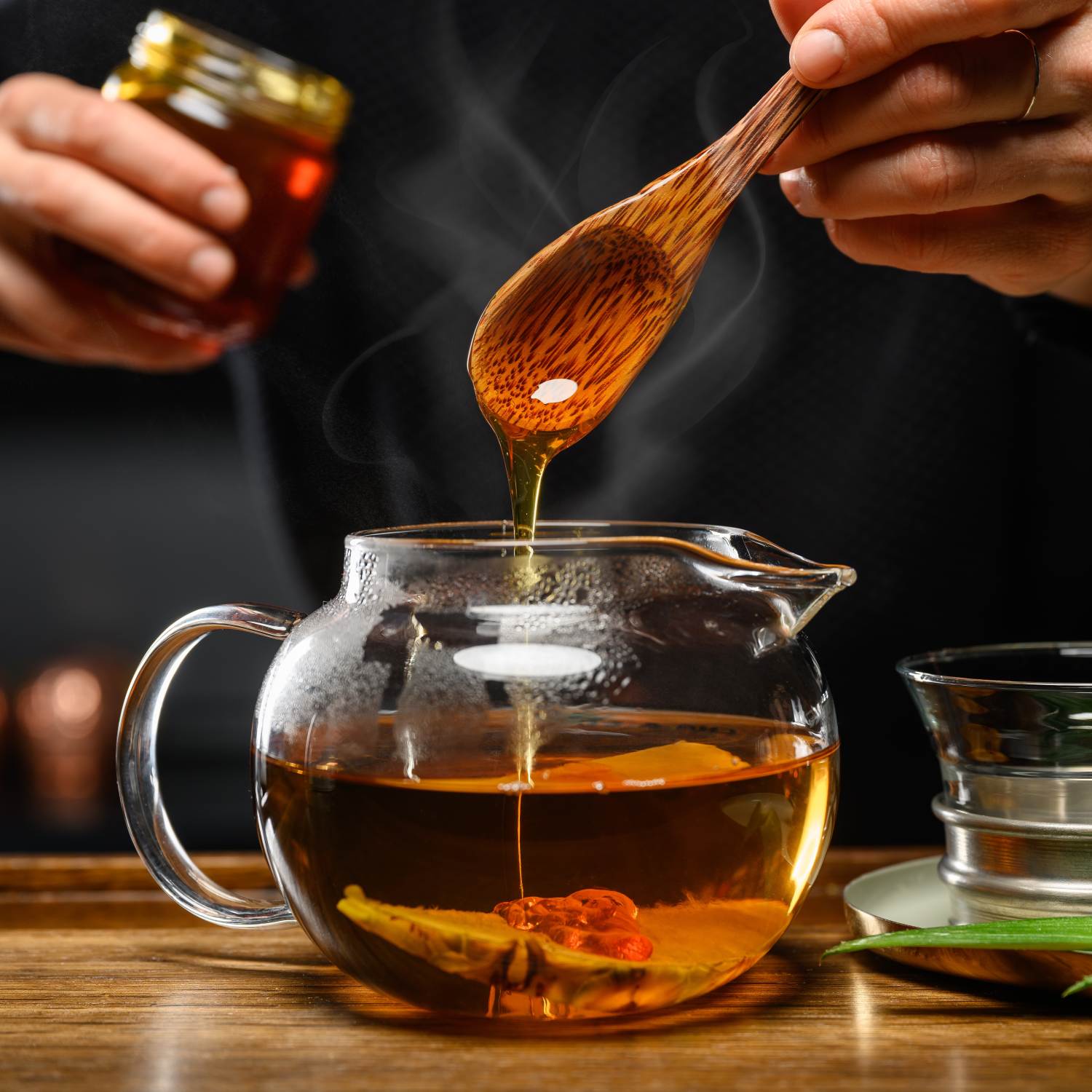 Nahaufnahme: flüssiger Honig läuft in dampfenden Tee