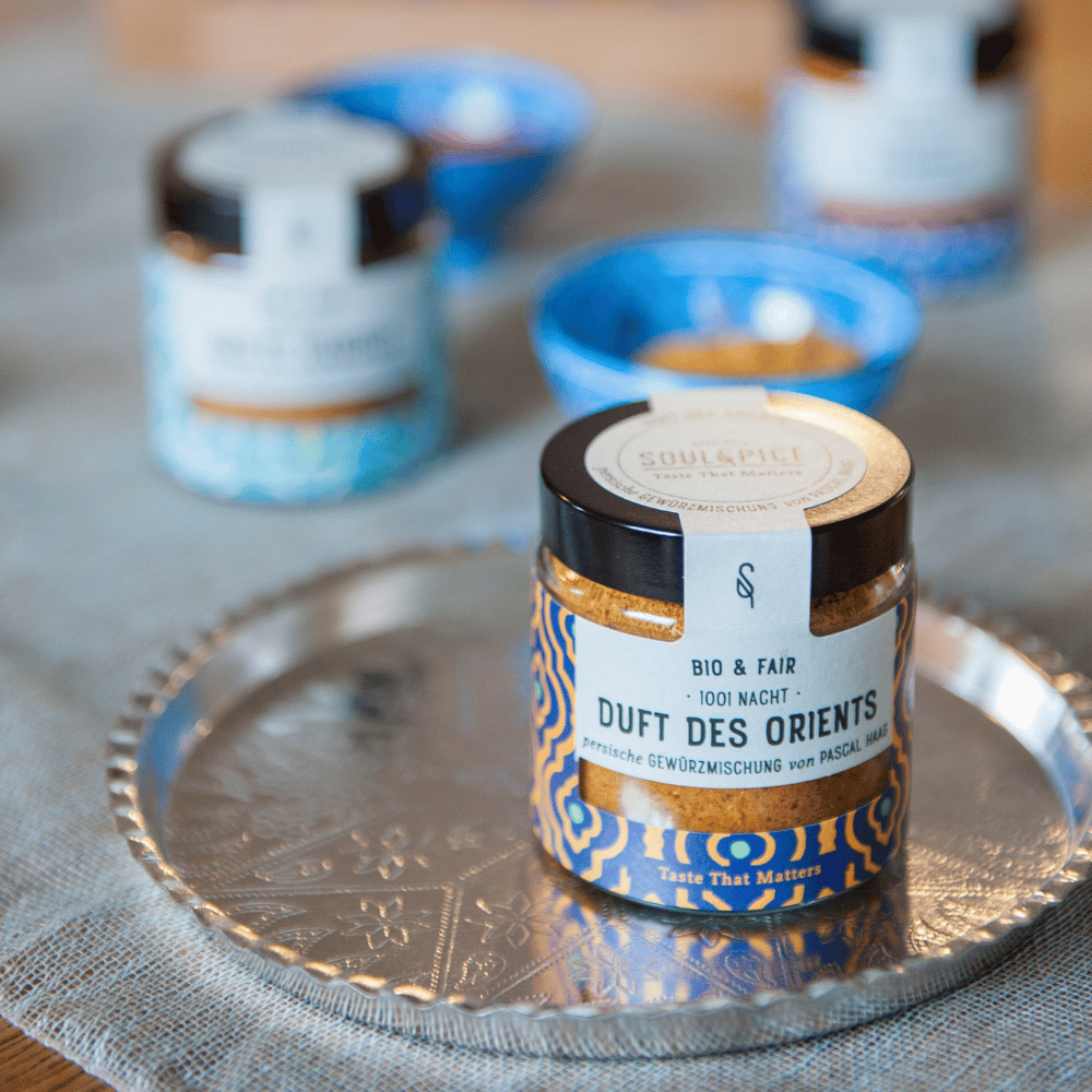 Bocal d’épices SoulSpice « Duft des Orients » bio et équitable sur un plateau argenté avec des bols en arrière-plan