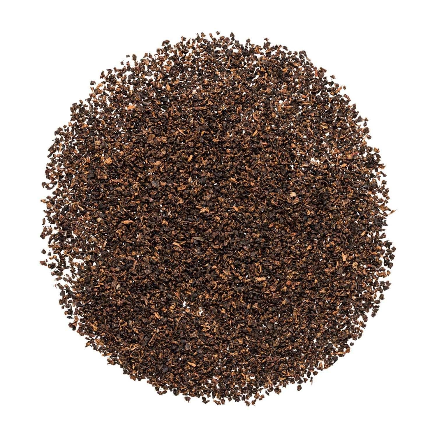 Runder Haufen loser schwarzer CTC-Tee auf Weiß, Kaffeegrinds, Kaffeemahlung, Kaffeepulver, Röstkaffee, Kaffeebohnenersatz