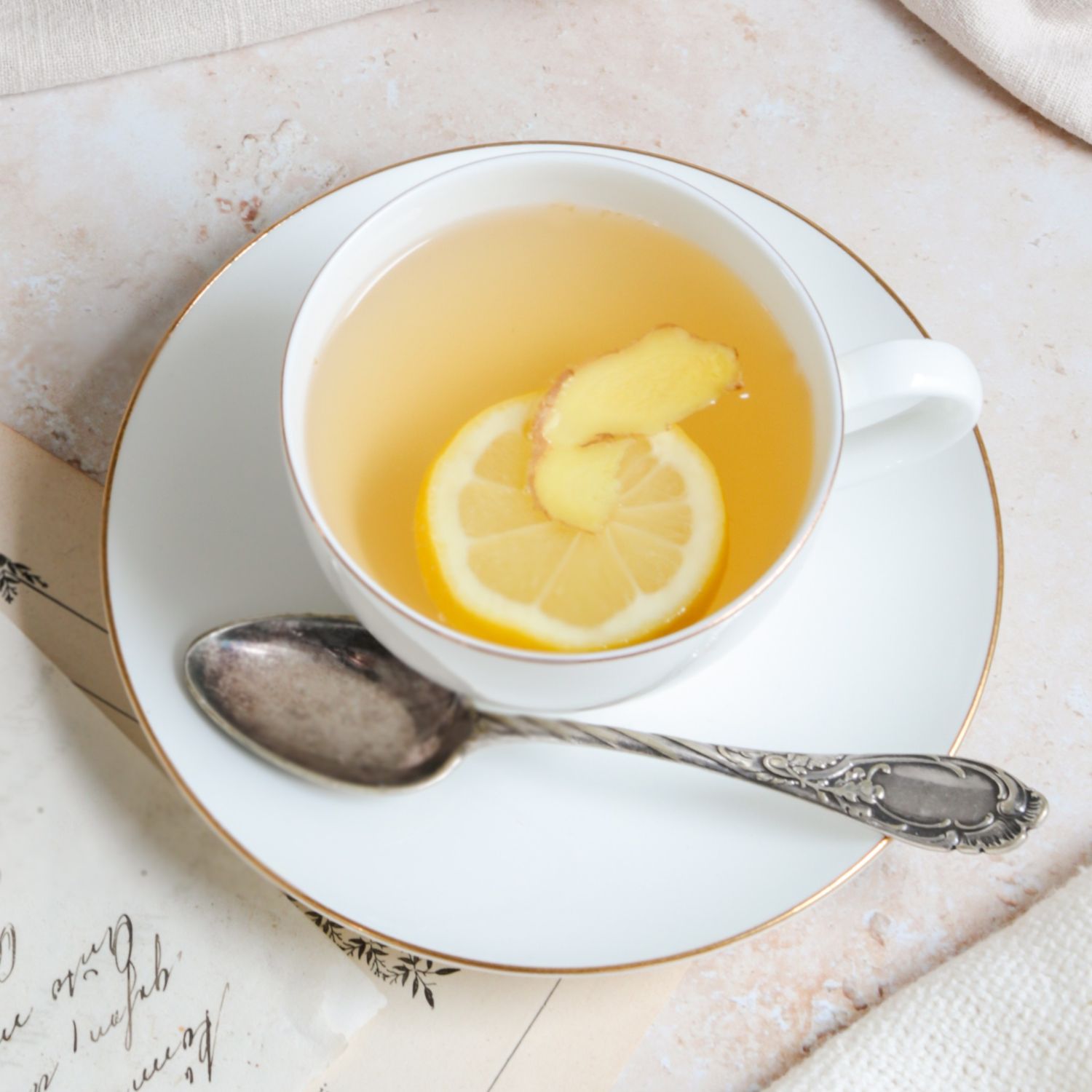 Weiße Teetasse mit Ingwer-Zitronen-Tee und Löffel