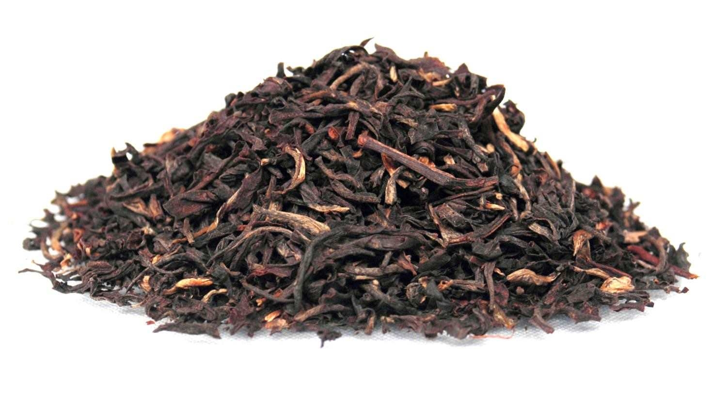 Haufen loser schwarzer Teeblätter auf weißem Hintergrund, Schwarztee, lose Blätter, Trockenprodukt, Kräutertee?, Rooibos?