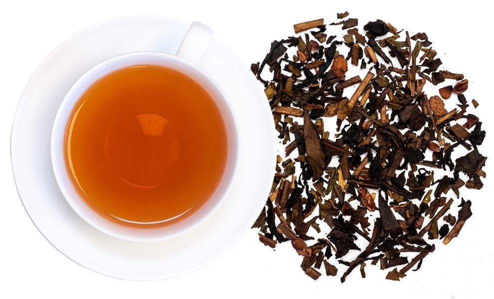 Weiße Teetasse mit losem Tee daneben, Tee, Schwarztee, Lose Blätter, Kupferfarbige Farbe, Tasse mit Untertasse