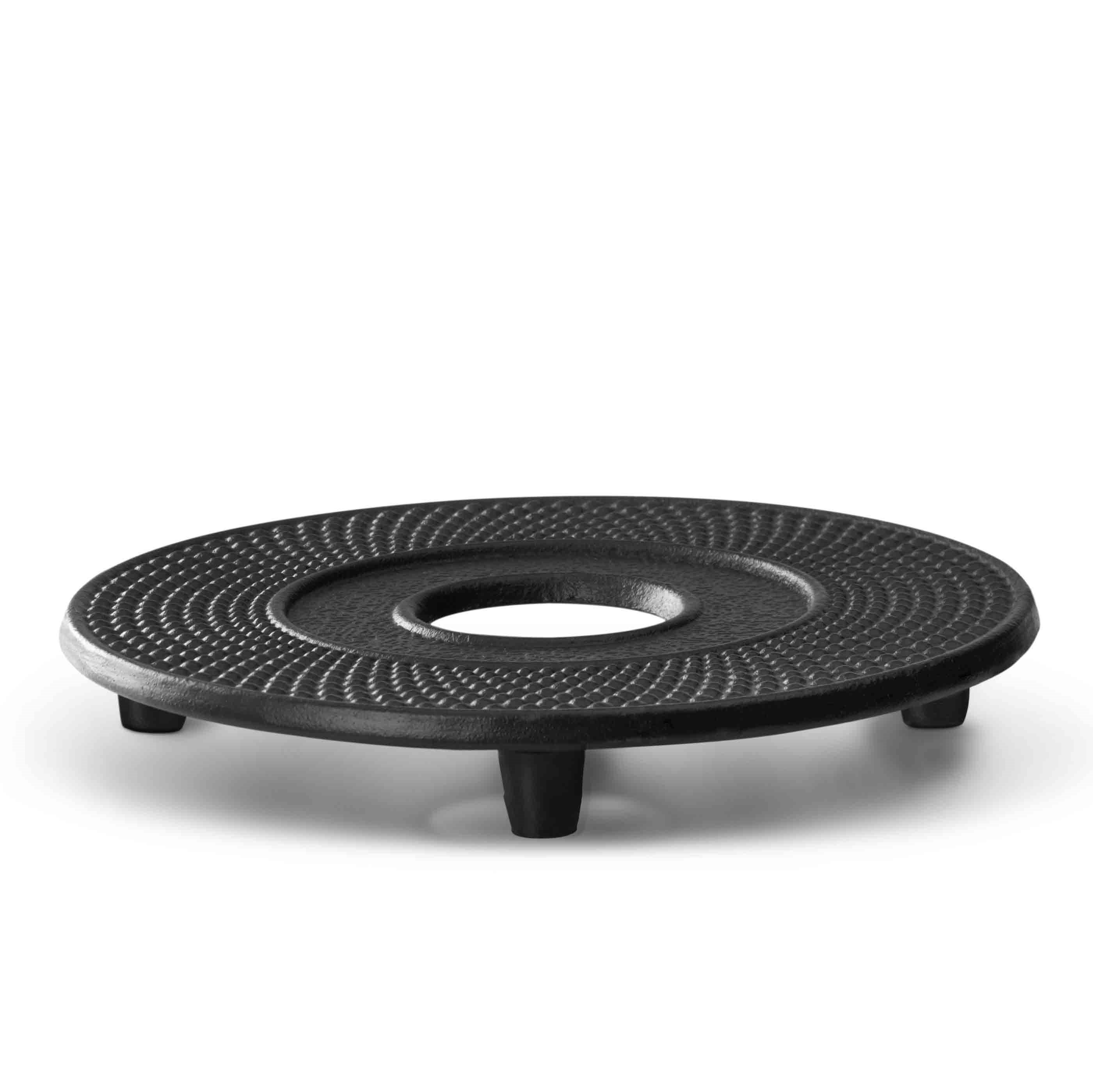 Black round cast iron trivet with feet