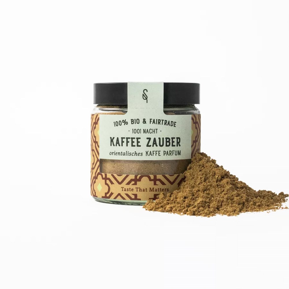 Bocal en verre de l’épice de café orientale 1001 Nuits Magie du Café bio et équitable avec un tas d’épice moulue à côté