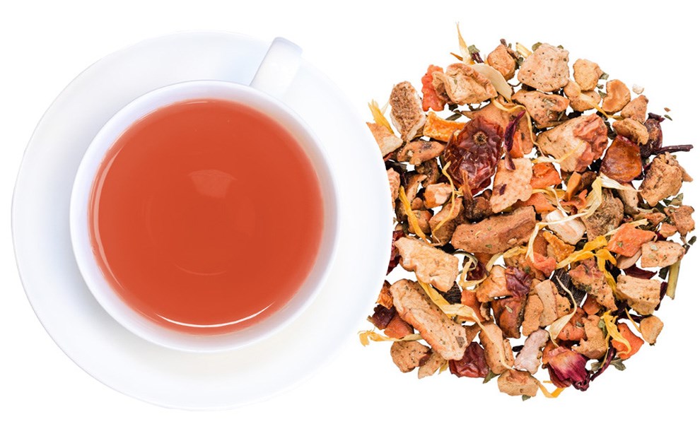 Weiße Tasse Früchtetee mit loser Tee-Mischung daneben, tee, teegetränk, kaffeeersatz, kräutertee, tassentee