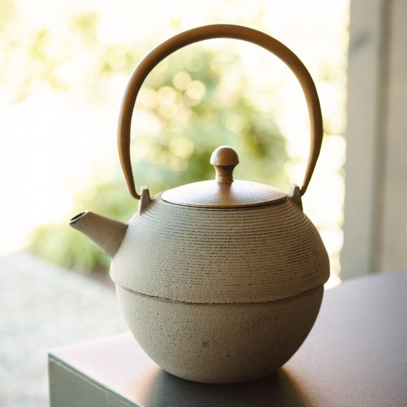 Round ceramic teapot with wooden handle