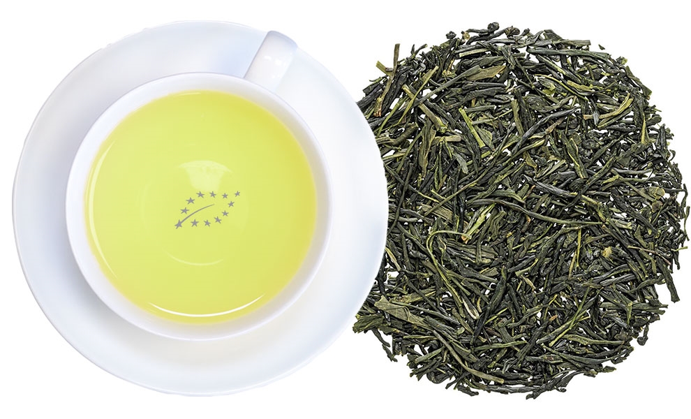 Tasse Sencha Grüntee mit losem Tee daneben, grüner tee, tee-blätter, weiße tasse, gelbe flüssigkeit, eu-organic logo