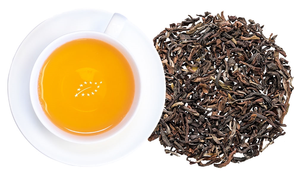 Weiße Tasse Schwarztee neben losen Teeblättern, Tee, Schwarztee, Teeblätter, Kurkuma?