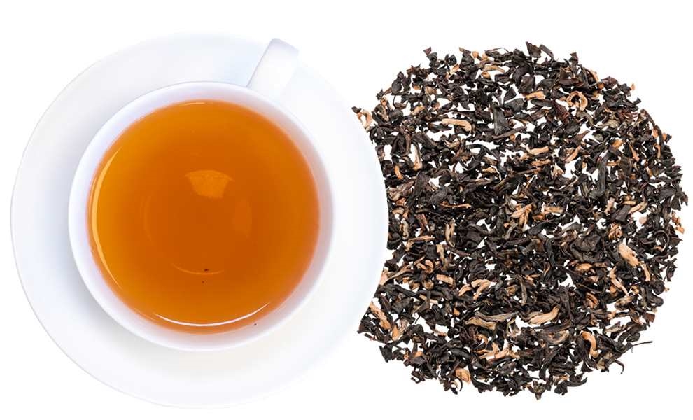 Tasse schwarzer Tee neben losen Teeblättern, Schwarztee, Teeblätter, Tee, Teekanne?, Teezubereitung