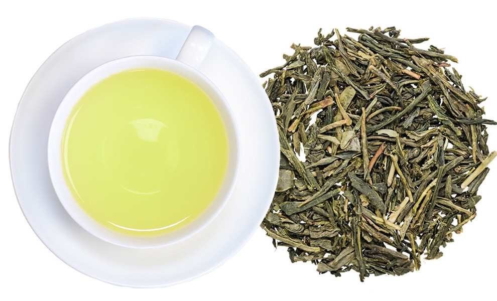 Hellgelber grüner Tee in weißer Tasse neben einem Haufen loser Grünteeblätter, grünertee, tee, blätter, aufnahme, kaffee? hmm, grüner tee, teeblätter, öl/tee, tasse tee, flache schale