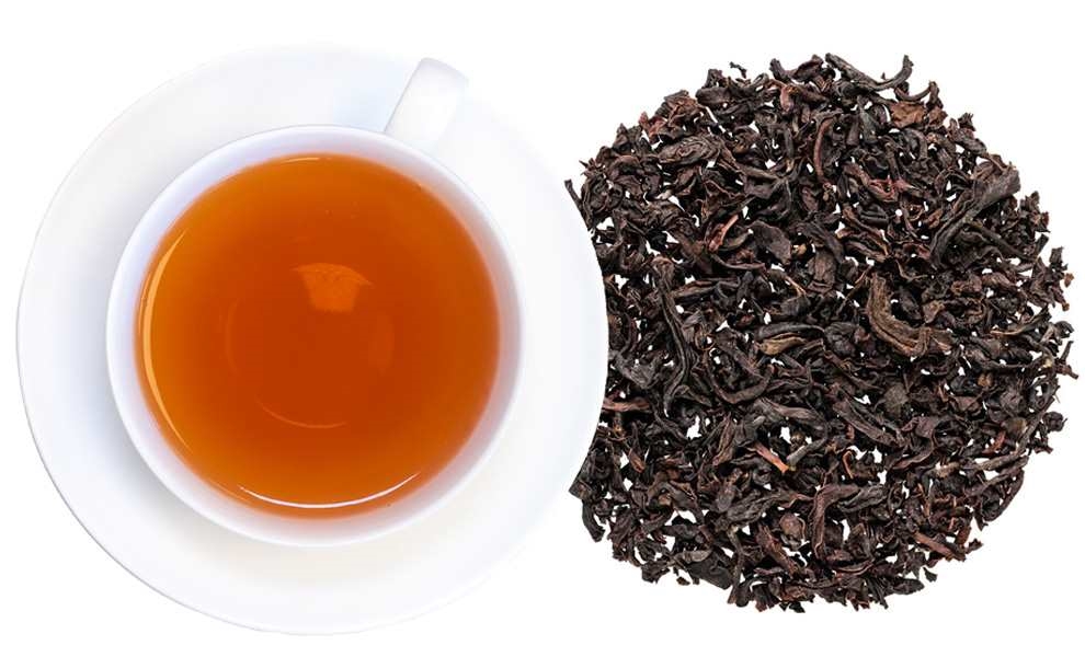 Tasse mit schwarzem Tee neben losem Schwarztee, Tee, Schwarztee, Teebeutel, Bräunliche Farbe, Kaffeetasse