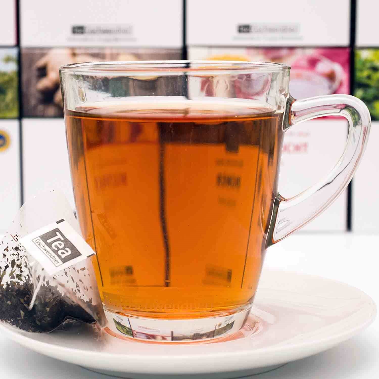 Heißer schwarzer Tee im Glas mit Teebeutel auf Teller, tee, tee, glass, heiße getränk, tee-beutel