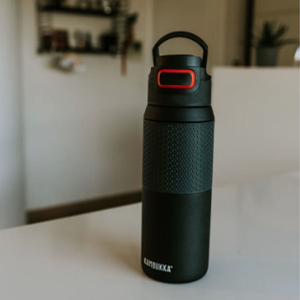 Schwarze Kambukka Thermoflasche auf Tisch, Trinkflasche, Wasserflasche, Stahlflasche, Schwarz, Grip-Oberfläche