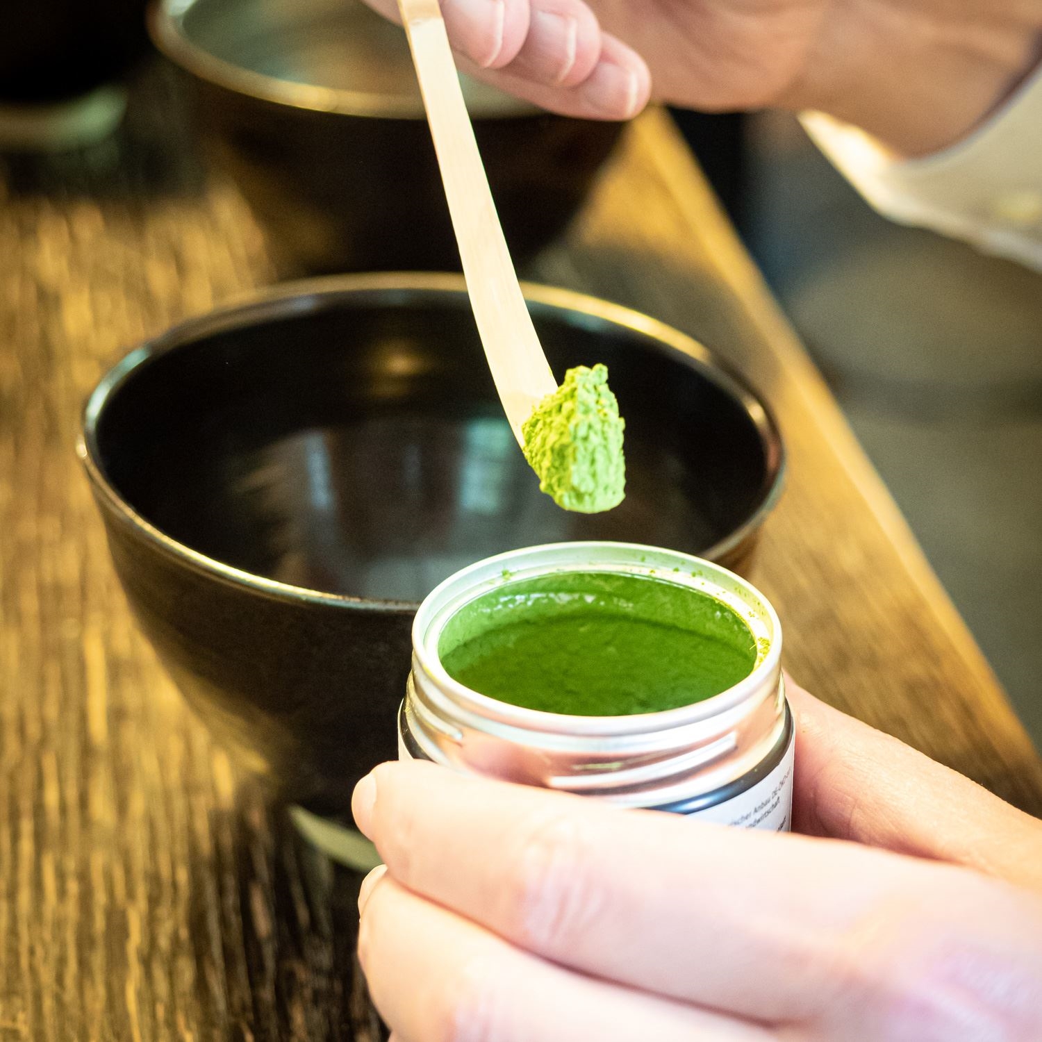 Hand dosiert frisches Matcha-Pulver in Teeschale, matcha, grüne paste, zeremonieller qualitätsgrad, pulver, behälter