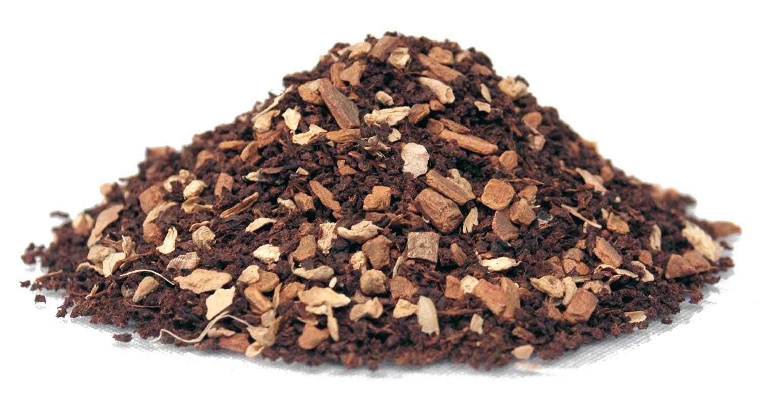 Haufen lose Gewürztee-Mischung aus dunklen Kräutern, Kaffeepulver, Kaffeebohnen, Kaffeekrümel, Kaffeegranulat, Röstung dunkel