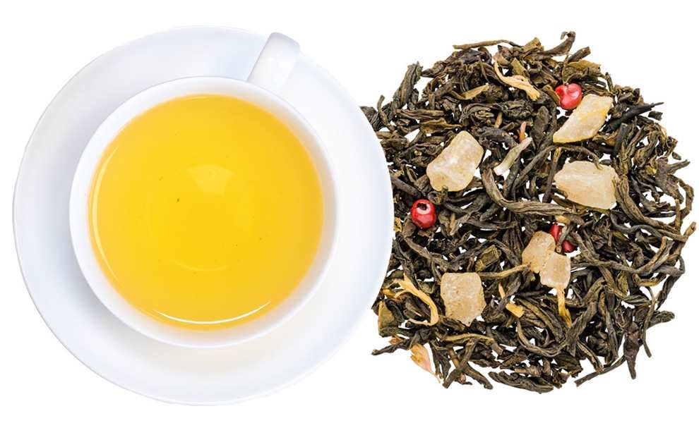 Tasse grüner Früchtetee mit losem Tee daneben, tee, tee-blätter, ostern, gelb-orange-tee, pulvertee?