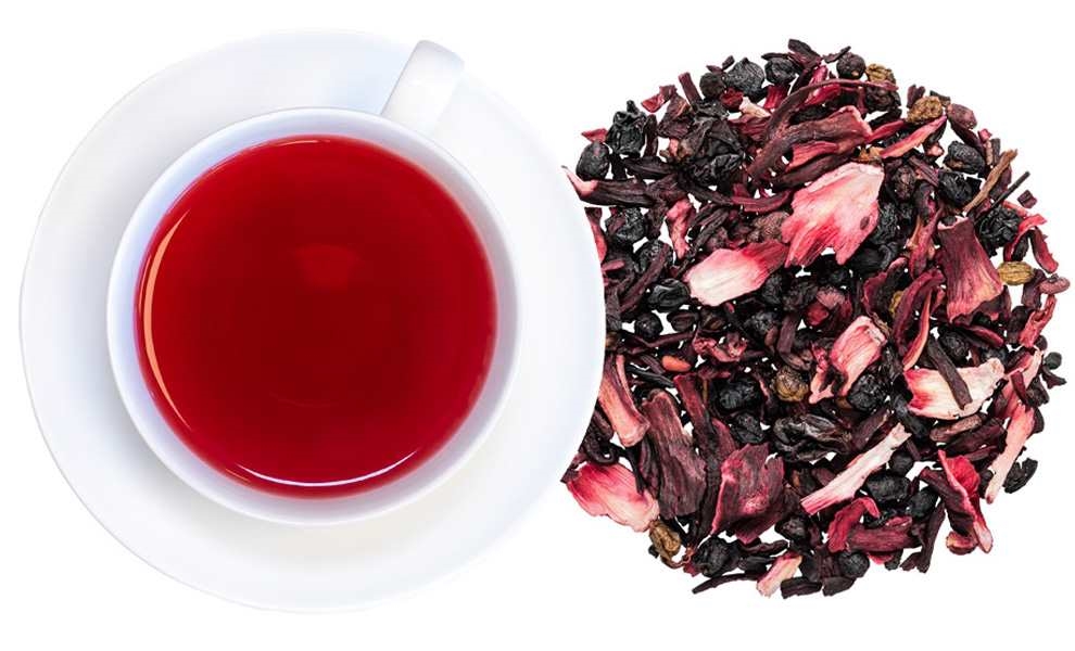 Weiße Tasse mit rotem Früchtetee und loser Teemischung, Rooibos, Tee, Kräutertee, roter Aufguss, Losertee