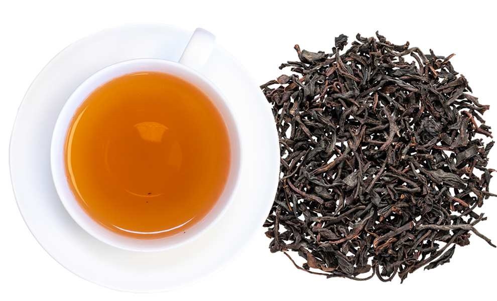 Tasse schwarzer Tee mit losen Teeblättern daneben, Tee, Schwarztee, Tee-Blätter, Kanne, Tassenset