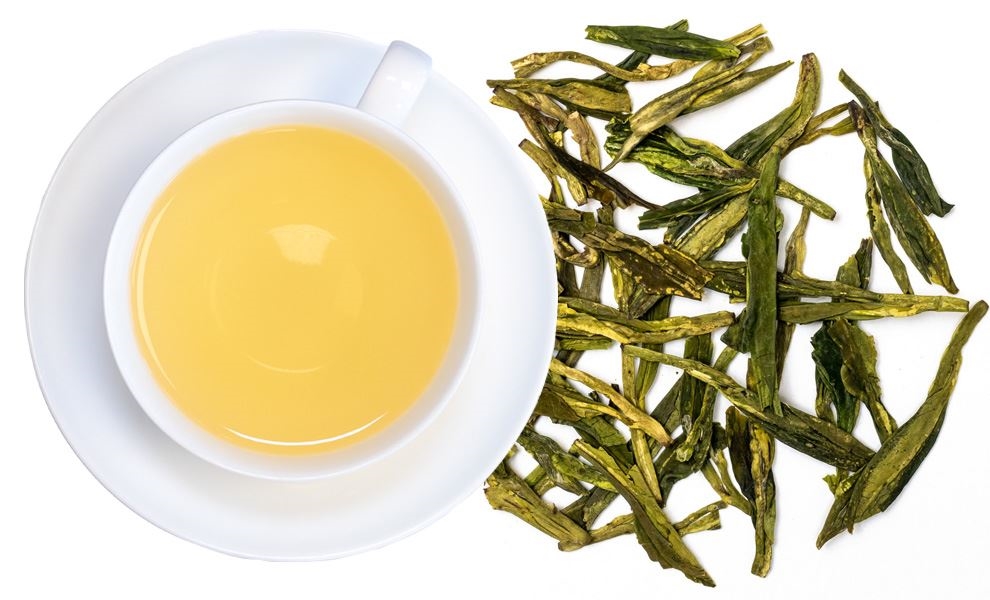 Weiße Tasse grüner Tee neben losen Teeblättern, tee, tasse, tee-geschirr, getränk, blätter-tee