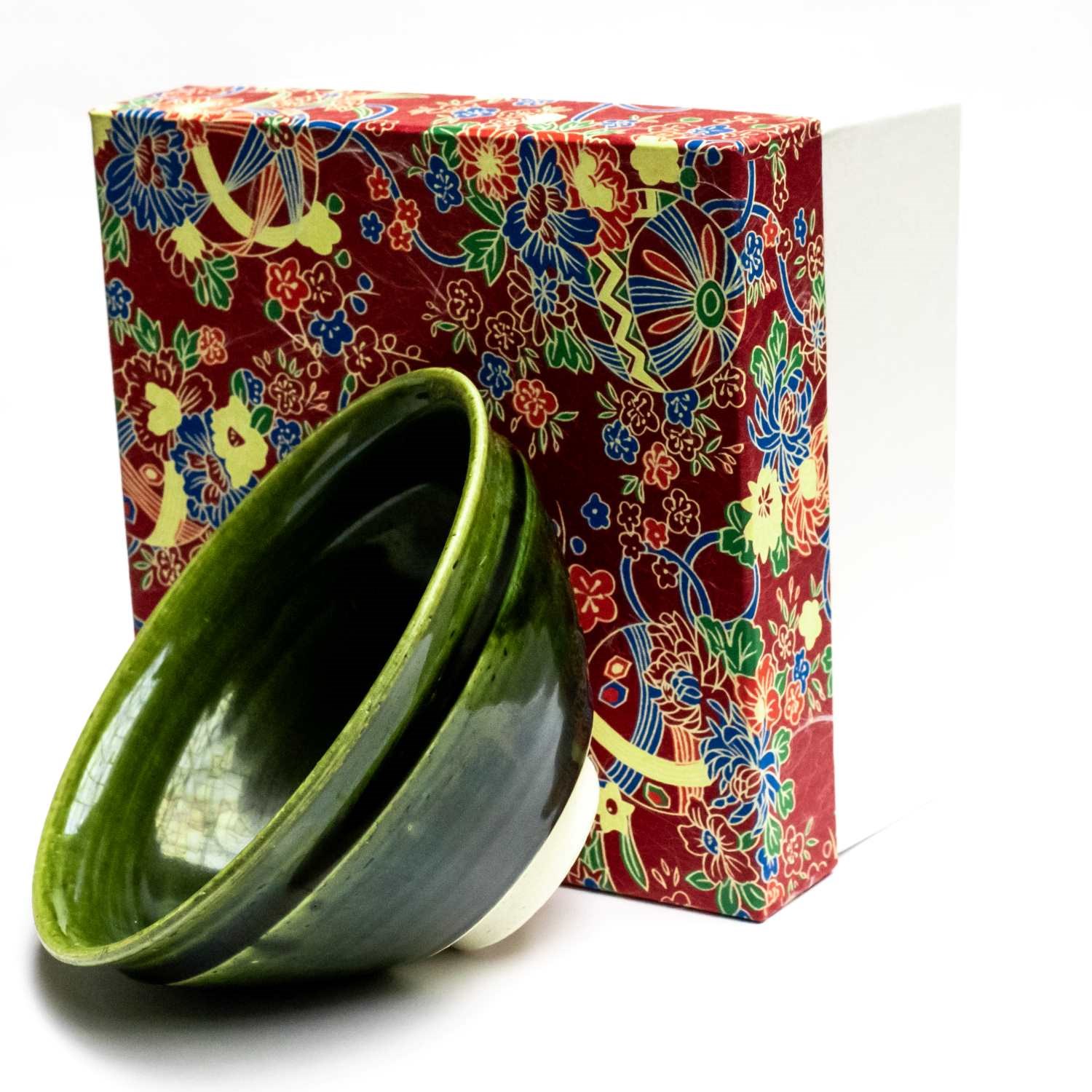 Grüne Keramikschale vor bunter Geschenkbox, Grünschale, Tee-/Schüssel-Behälter, Keramikschüssel, Grüne Keramik, Dekorativ-Glasur