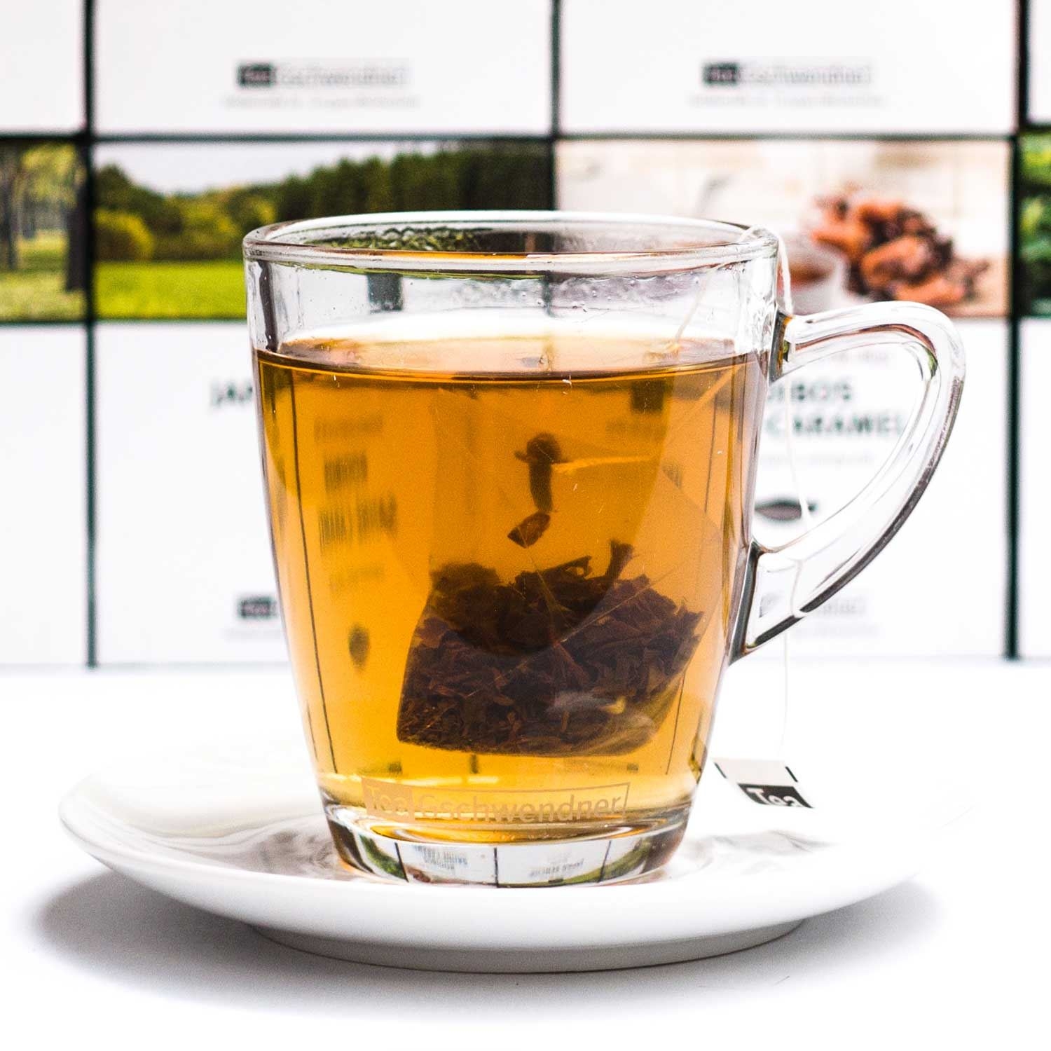Heißer Tee im Glas mit Teebeutel auf Untertasse, tee, Teebeutel, Glasbecher, heiße Getränke, Kräutertee
