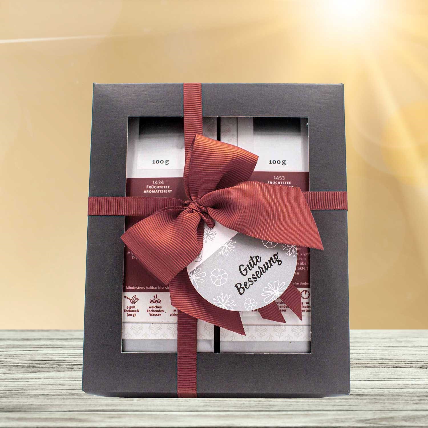 Geschenkbox mit Tee und roter Schleife Gute Besserung, Geschenkset, Likör-Set, Schachtel, Band, Label/Grußkarte