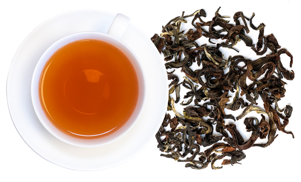 Weiße Tasse Oolong-Tee mit losen Teeblättern daneben