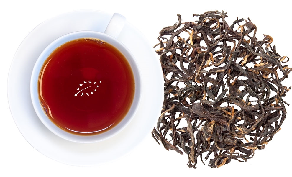 Weiße Tasse mit schwarzem Tee neben losen Teeblättern, Tee, Schwarztee, Teeblatt, Kanne, Teeblatt