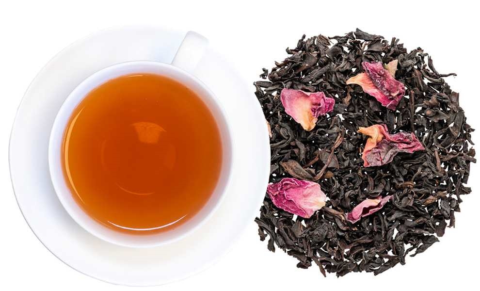 Tasse schwarzer Tee neben losen Rosenblütentee, Tee, Schwarztee, Blätter, Rose, Kanne
