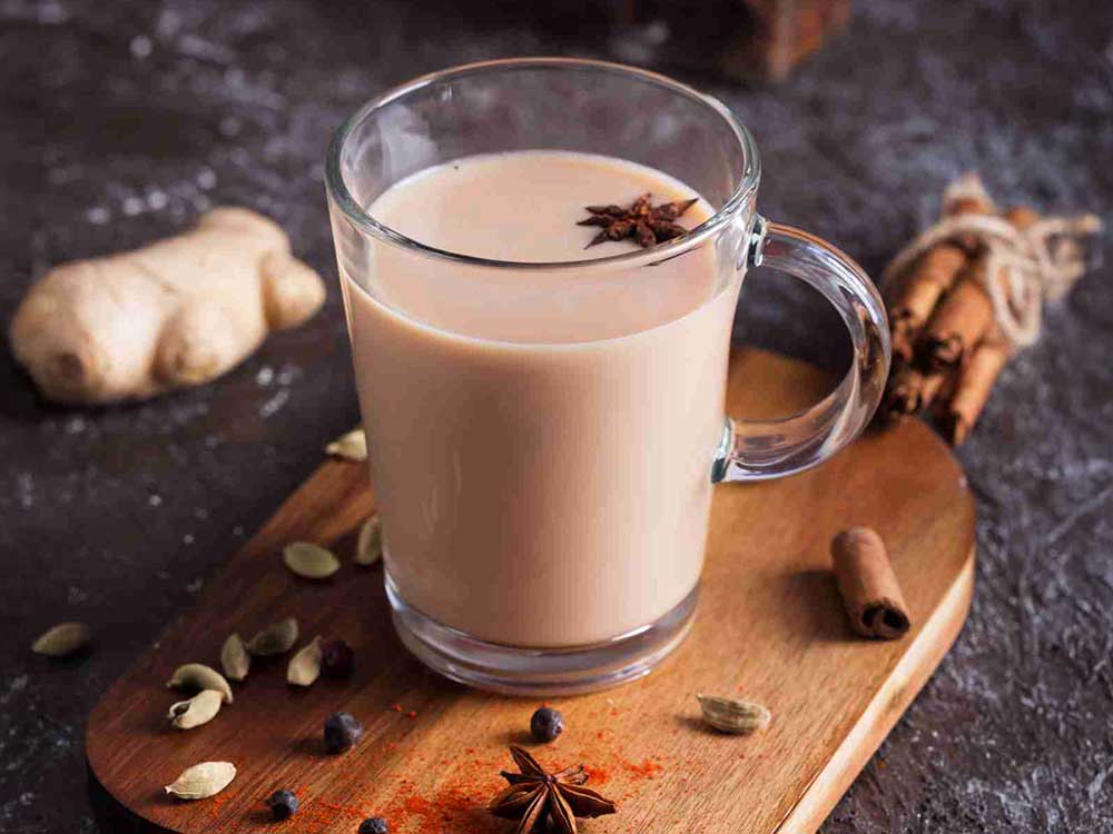 Glas gefüllt mit cremigem Chai Tee und Sternanis