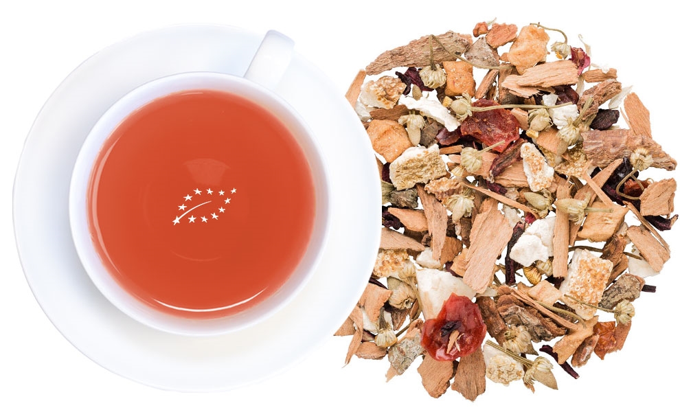 Weiße Tasse Früchtetee neben loser Teemischung, tee, teegetränk, kraeutertee, kupferfarbener tee, zubereitungspartikel