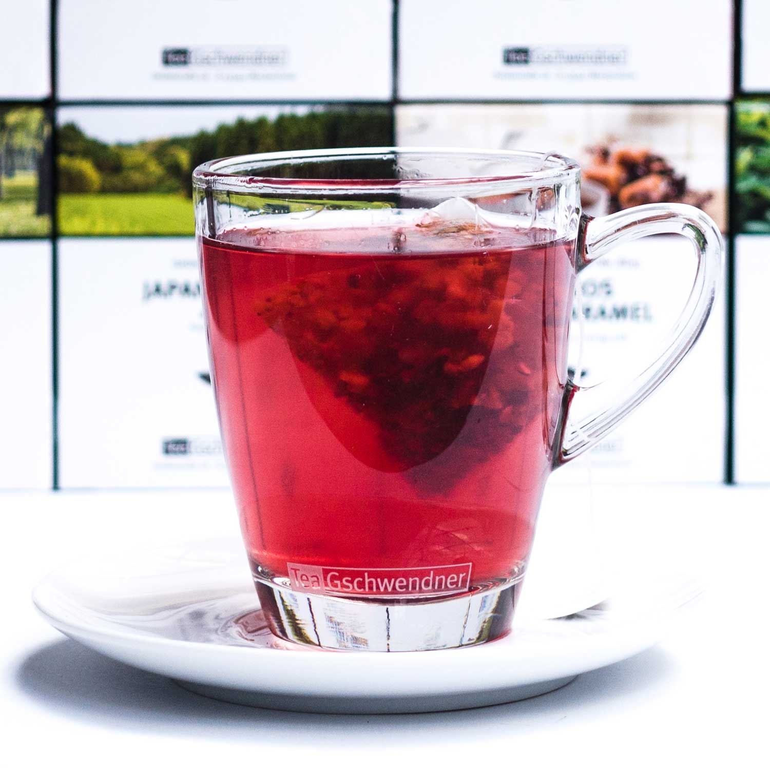 Roter Früchtetee in Glastasse auf weißer Untertasse, glas, Teebecher, roter Tee, Tee-Infuser, Griff