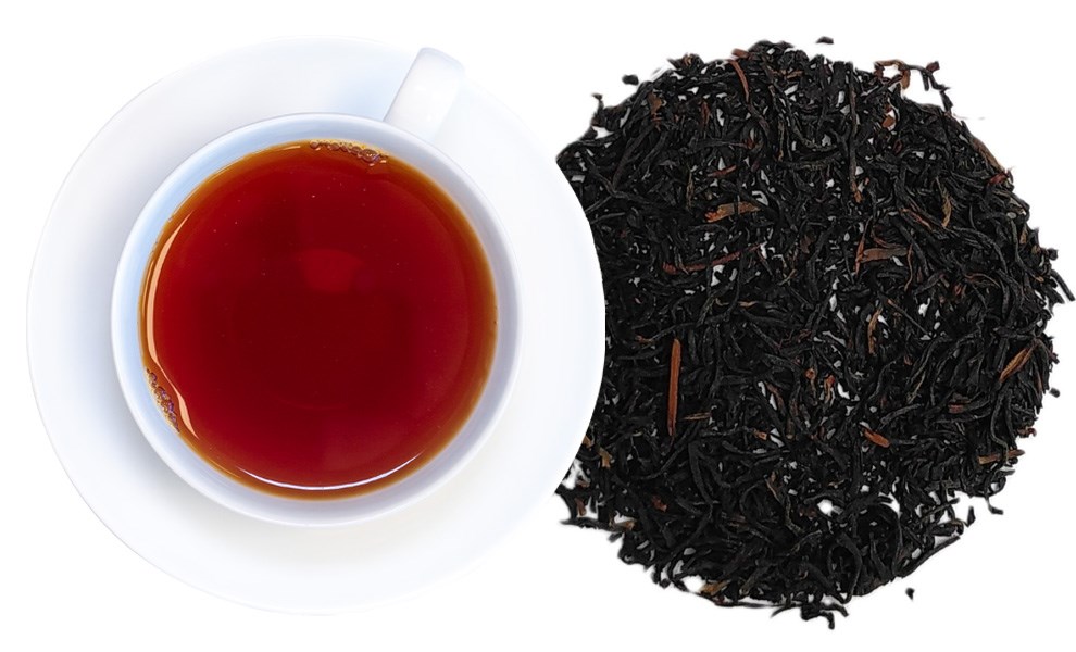 Tasse Schwarzer Tee und lose schwarze Teeblätter auf weißem