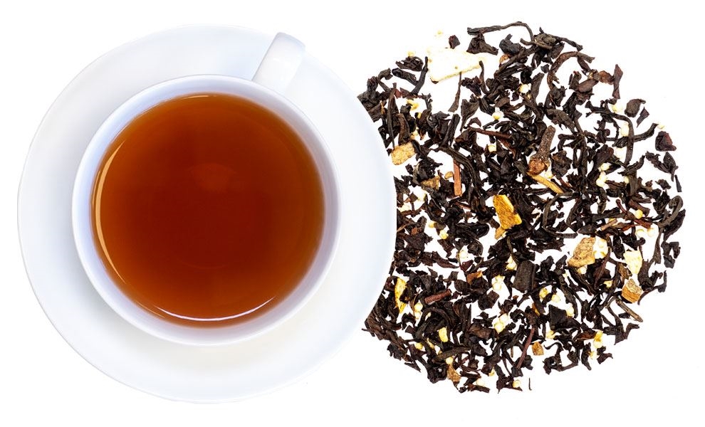 Weiße Tasse Schwarztee neben losen Teeblättern, Tee, Schwarztee, Loseteeblätter, Kaffeetasse?