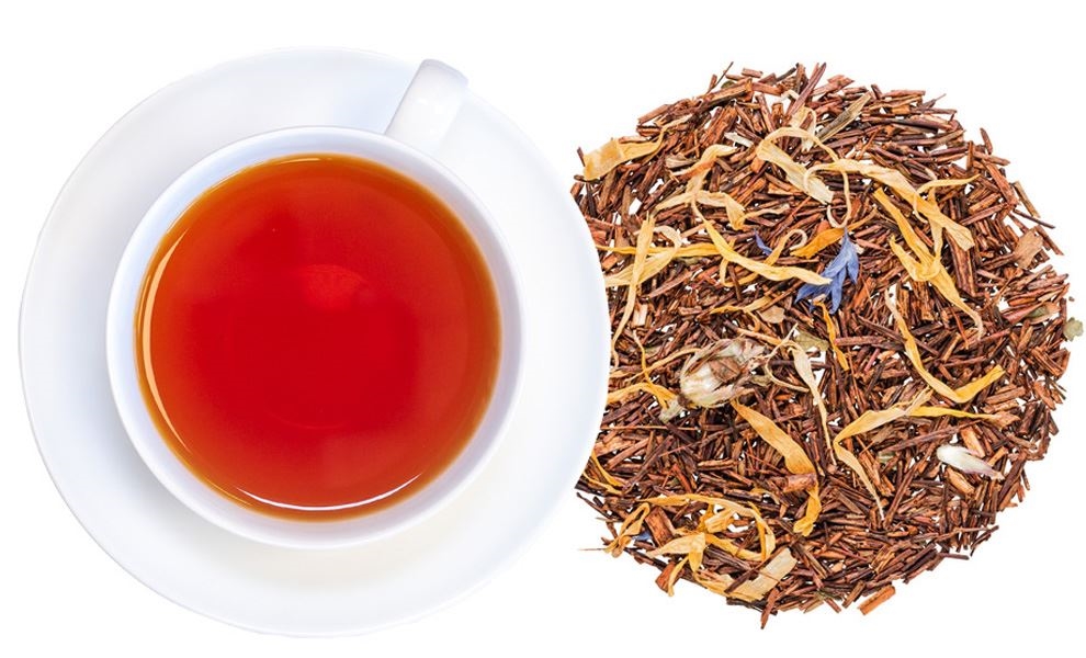 Weiße Tasse mit Rooibostee neben losem Rooibostee, tee, teeblätter, RoteTee, Kräutertee, Teeblätter