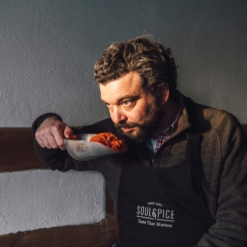 Mann riecht an rotem Gewürz in SoulSpice-Schürze