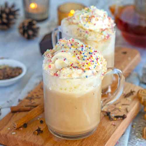 Glas Latte mit Sahnehaube und bunten Streuseln