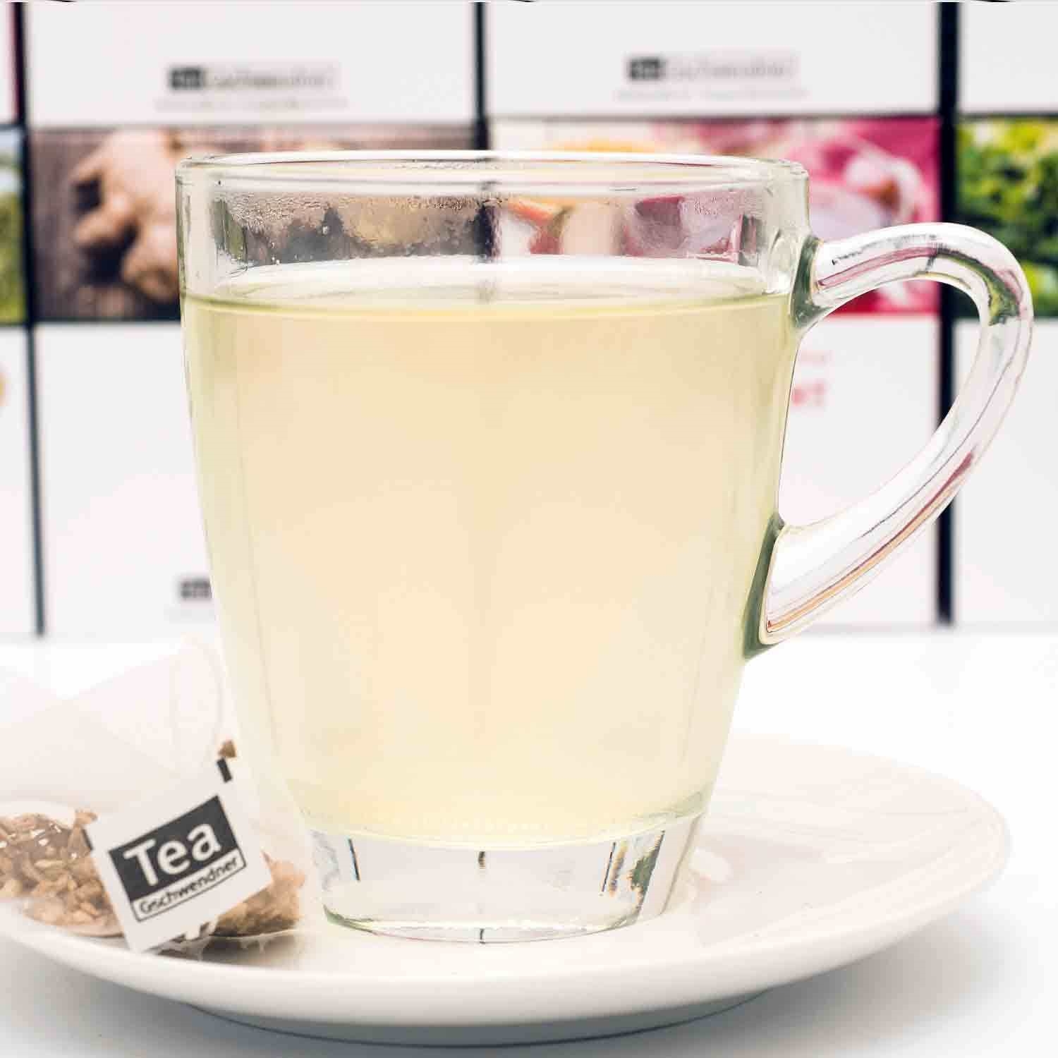 Heißer Kräutertee im Glas mit Teebeutel auf Teller,  Tee,  Gläserner Becher,  Heißgetränk,  Wassertee,  Teebeutel