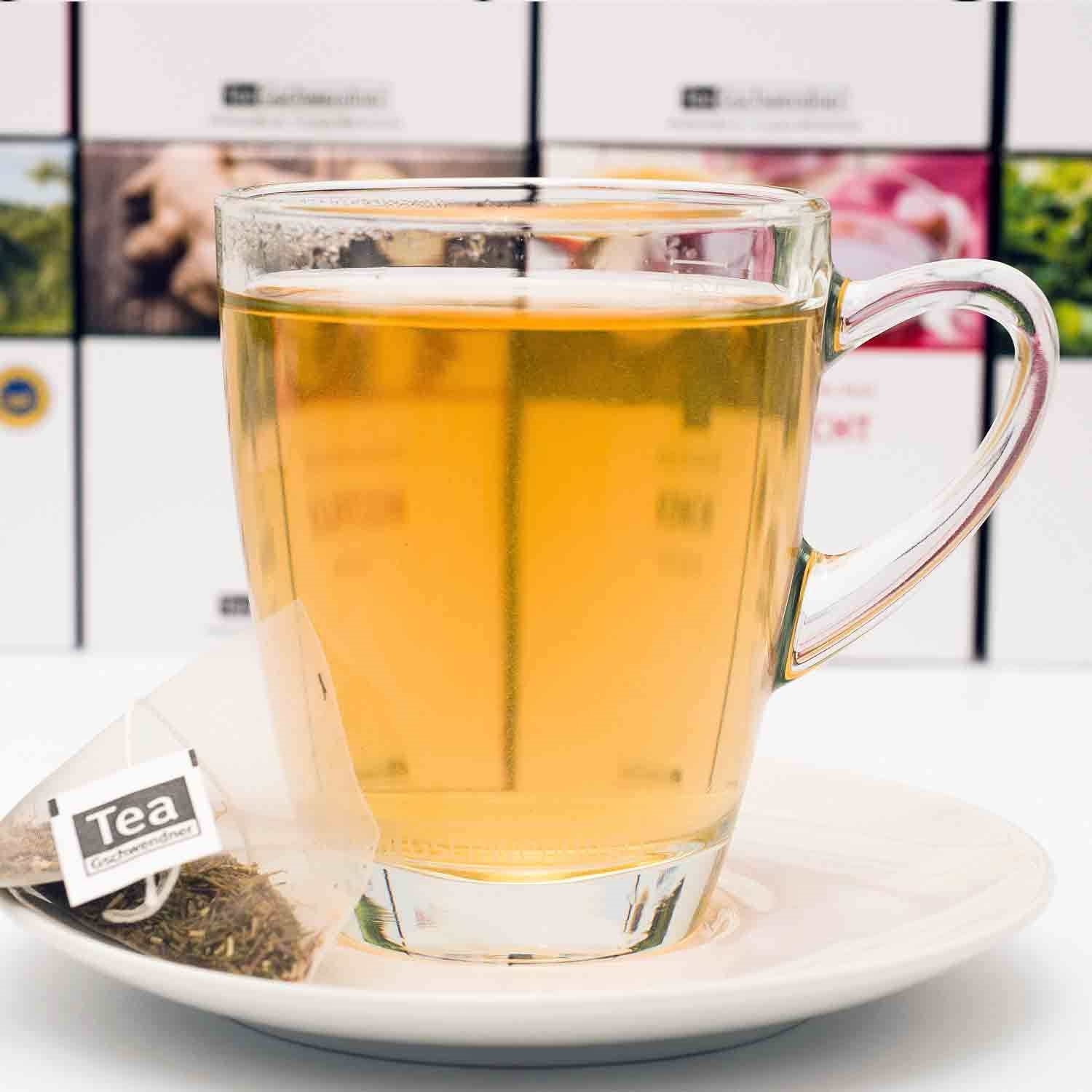 Heißes Teegetränk im Glas mit Teebeutel, glasbecher, tee, heißgetränk, klarglas, teebeutel auf teller