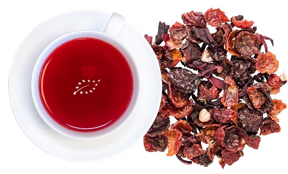 Weiße Tasse mit rotem Hagebuttentee und Trockenfrüchten, Himbeersaft, Hibiskustee, Rottee, Tee, Obsttee