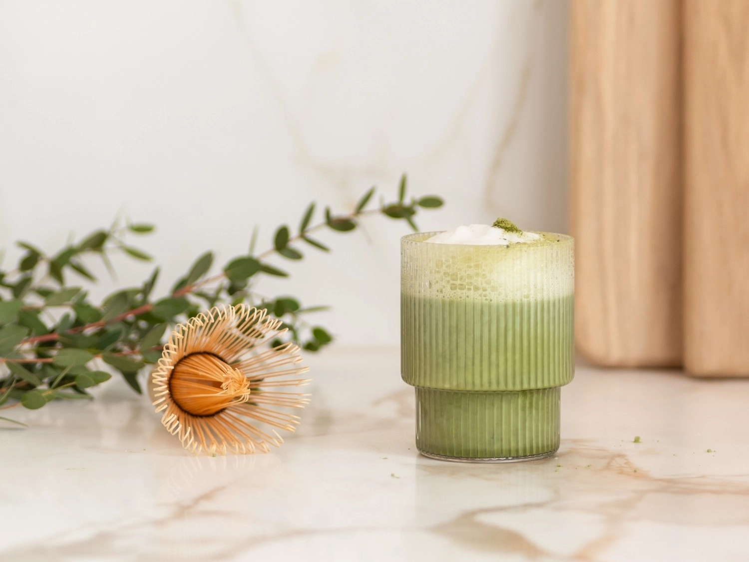 Grüner Iced Matcha Latte mit Schaum im Glas