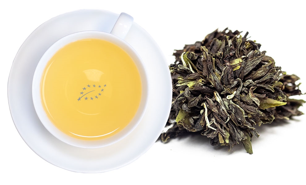 Weiße Teetasse neben gepresstem Weißtee-Ball, tee, tee-setup, tee cup, tea leaves, kräutertee