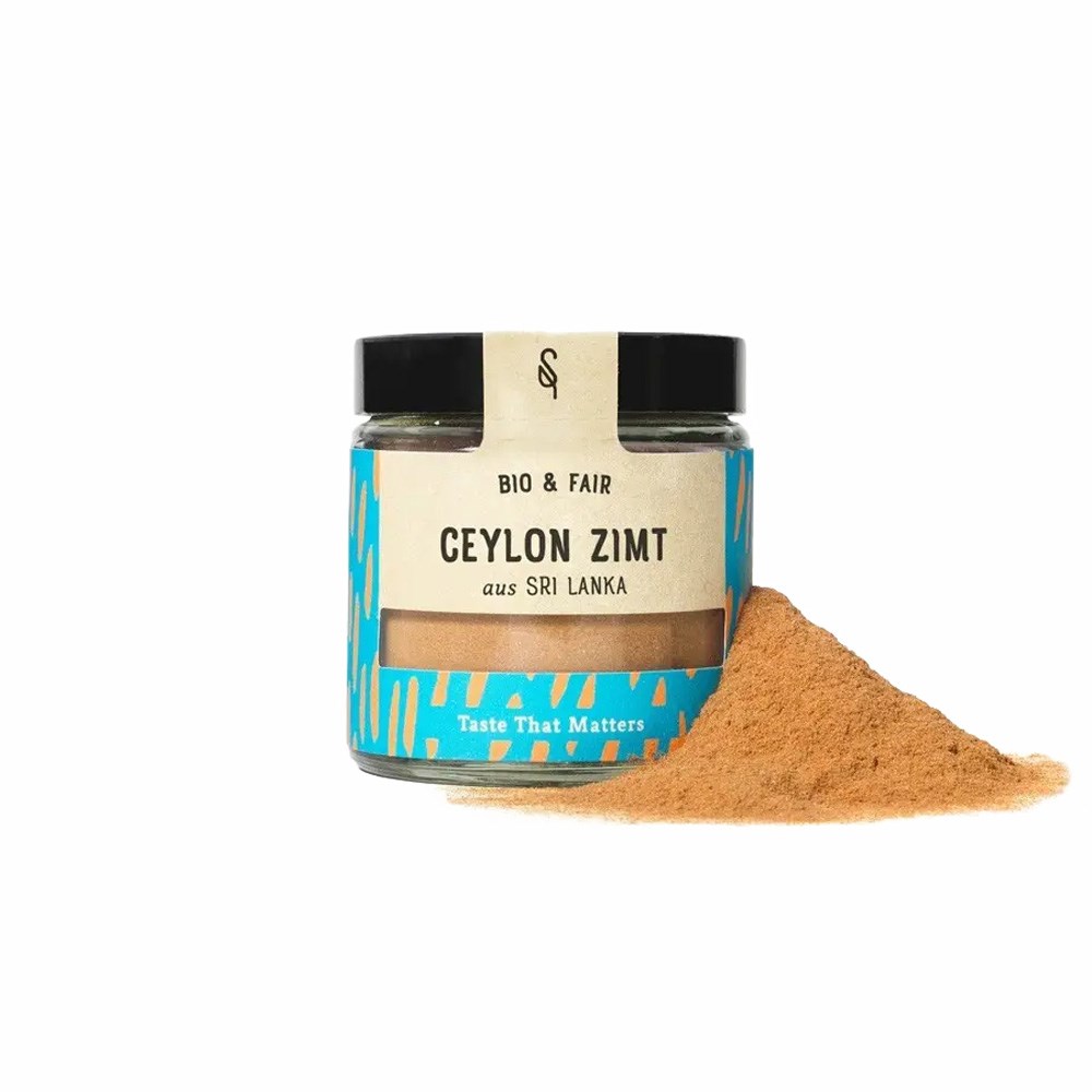 Bocal de cannelle de Ceylan biologique & équitable du Sri Lanka avec un tas de cannelle moulue à côté